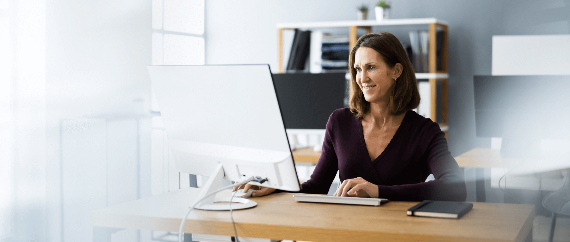 happy woman in office on computer