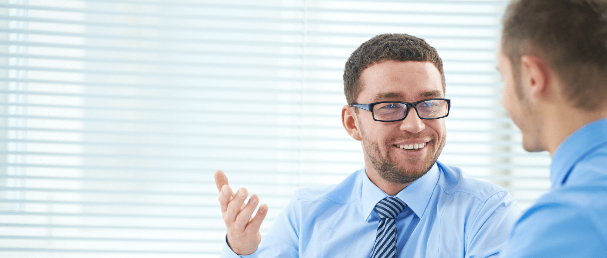 man with glasses smiling in office