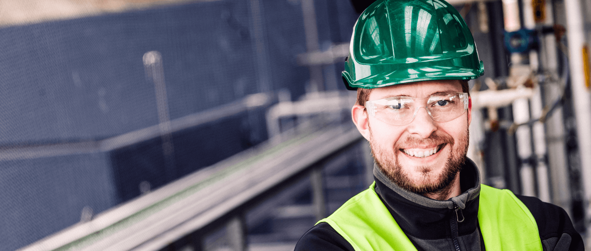 smiling construction worker with hardhat and safety glasses