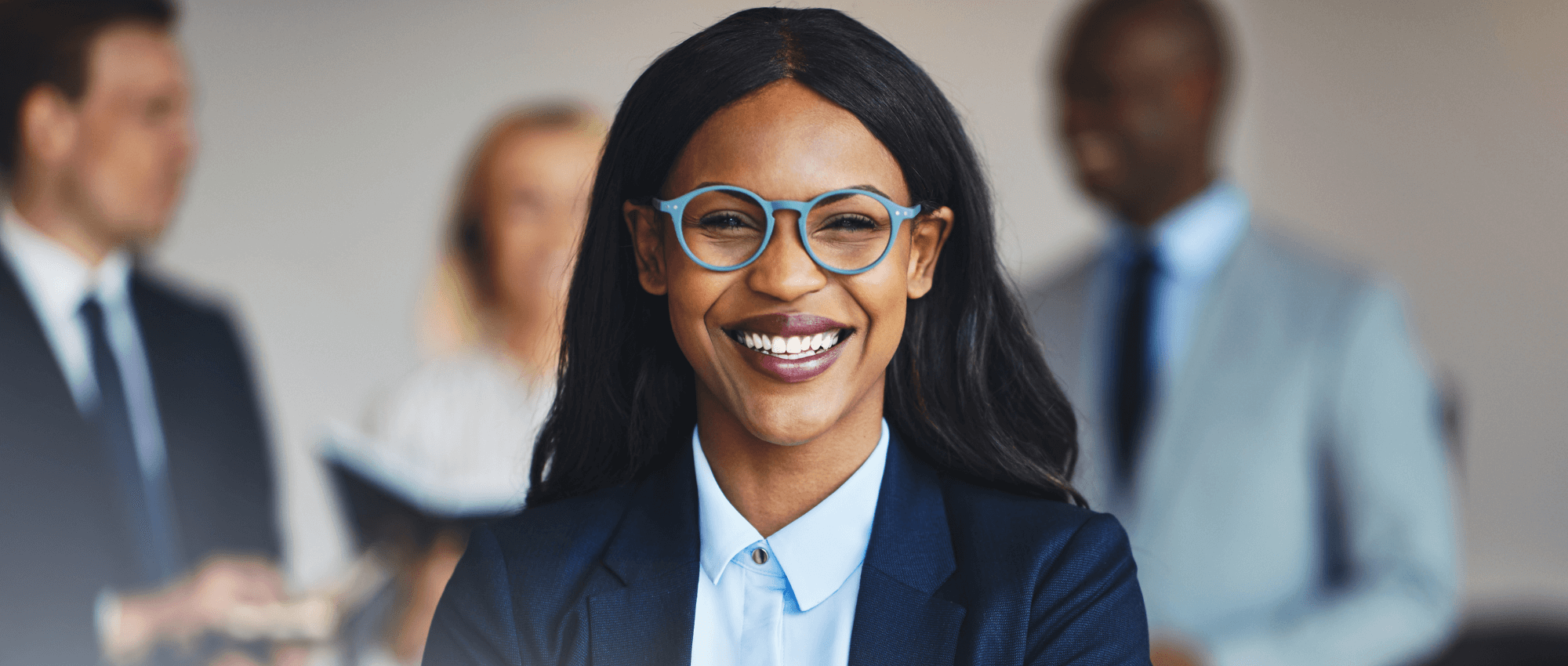 A business woman who is wearing glasses smiling