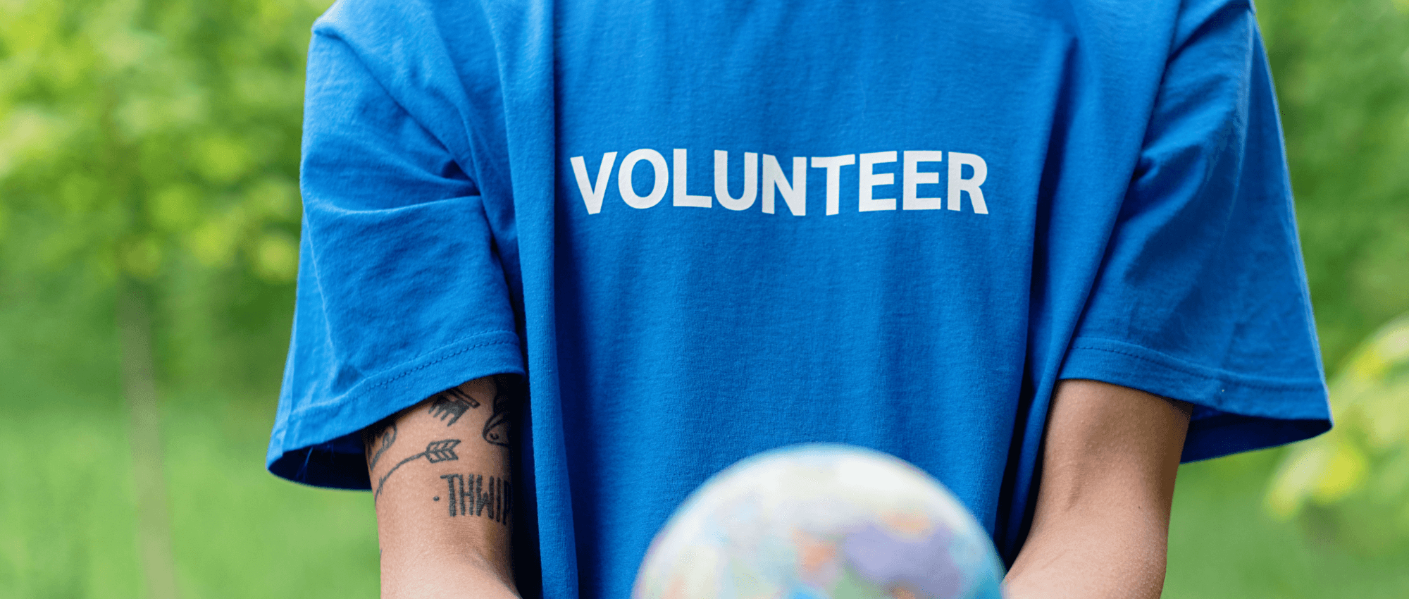 A person wearing a blue volunteer shirt