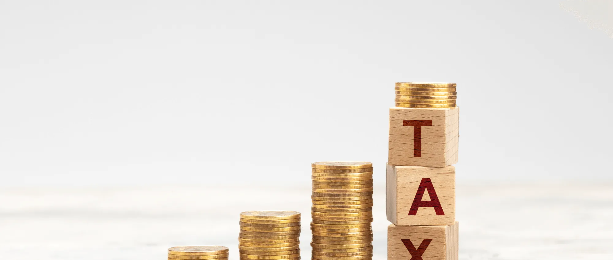 Golden dollars and three cubes that has letters T A X on each