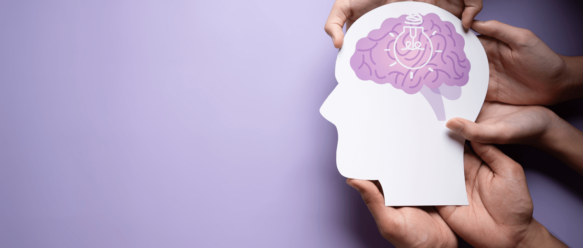 People holding a head card that shows where the brain is and a white outline lamp on it on a purple background