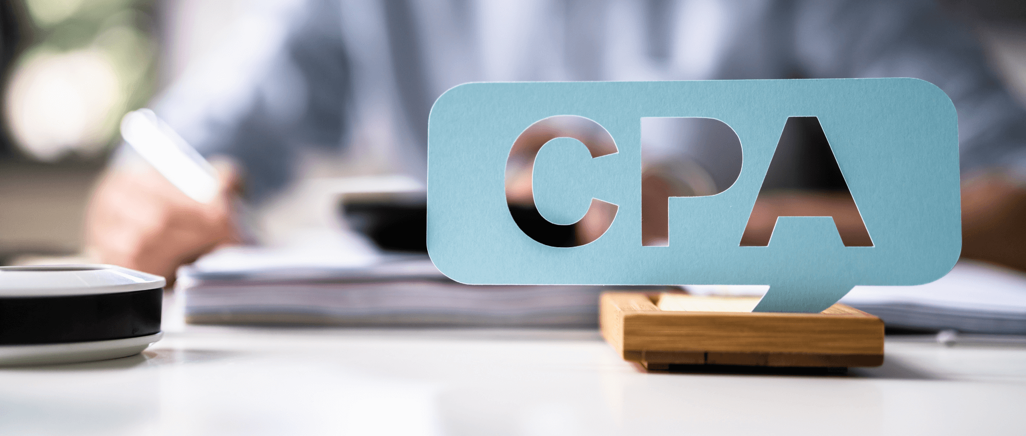 CPA letters cut from a blue sheet that is held on a wooden support