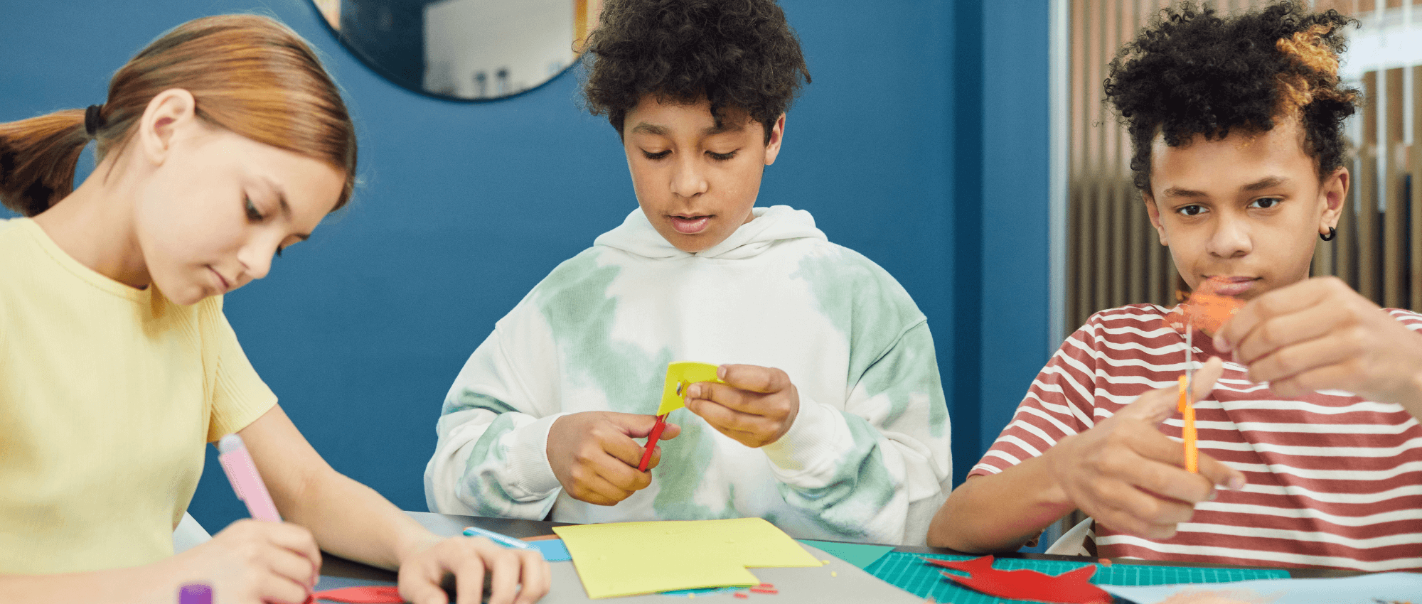 Children cutting paper in a crafts session